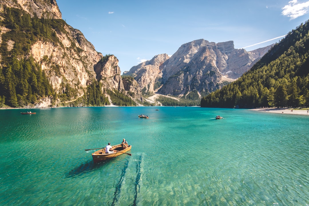 three-brown-wooden-boat-on-blue-lake-water-taken-at-daytime-t7k4aepoggk